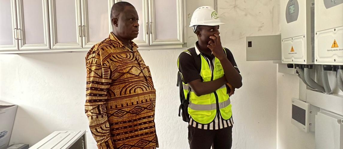 Dr. Karnuah inspects electrical system at one of the solarized laboratories.
